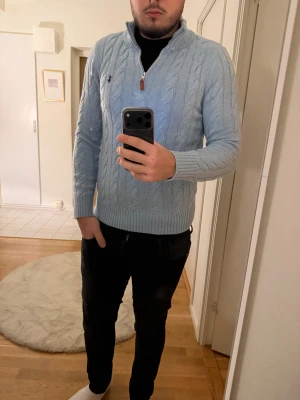 Polo Ralph Lauren stickad tröja S - Säljer en ljusblå stickad tröja från Polo Ralph Lauren med klassiskt kabelstickat mönster. Tröjan har half zip-dragkedja vid halsen, ribbade muddar och lång ärm. Perfekt för lager-på-lager och snygg till jeans. Ny skick på den 10/10 använt knappt. Kan diskutera om priset! 