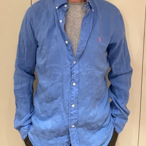 Blå skjorta från Ralph Lauren - Säljer denna stilrena Ralph lauren skjorta. Skjortan är i fräscht skick och passar till en lugn outfit. Modellen är 184 och väger 71 kg. Vid behov av bilder eller frågor om skjortan är det bara att skriva! Pris ej hugget i sten!