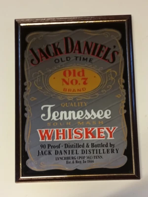 framed Jack Daniel’s Old Time Tennessee Whiskey Mirror  - This framed Jack Daniel’s Old Time Tennessee Whiskey Mirror is in very good condition. The frame size is 22 cm in width and 32 cm in height. The print is clean and well preserved, with no visible damage, stains, or fading. The frame is intact and stable, showing only minimal signs of normal handling. Overall, the picture presents very well and is ideal for decoration, collection, or display.