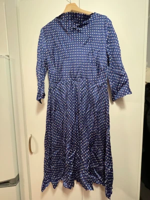 mörkblå polkadot klänning - mörkblå klänning med prickigt mönster från miss clarity! klänningen är i ett silkesliknande material och stängs med en dragkedja på ryggen. uppskattad storlek XL-XXL, men skriv för mått m.m. <3