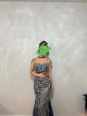 Glittrig långklänning med pärldetaljer - Säljer en fantastisk långklänning i mörkblått med glittriga detaljer och pärlor. Klänningen är använd endast en gång .Perfekt för bal eller festliga tillfällen.