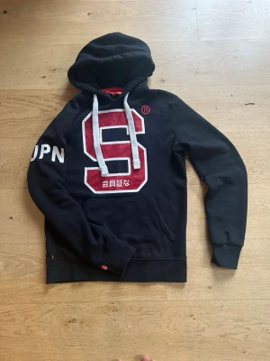 Superdry hoodie (sällsynt) XS - Fet superdry hoodie som passar i alla lägen! Sjukt stilren och skön. Men även från det eftertraktade märket Superdry. FAST PRIS!!!!!! 