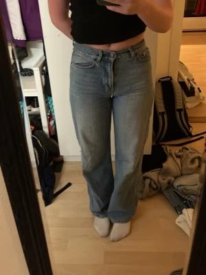 XS, L tip ljusblåa raka jeans - Säljer ett par ljusblå jeans med hög midja och raka ben. Klassisk Intvättad denim-look med fem fickor och gylf med dragkedja och knapp. hybrid mellan loose och straight fit, perfekta till sneakers eller boots. Fråga mig om ni undrar något😊