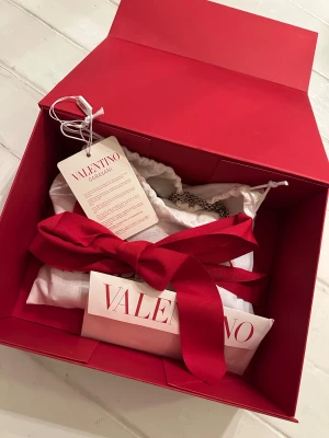 Valentino Väska - Valentino Rockstud spike nappa leather crossbody clutch bag i färgen poudre, mycket bra skick. Värdebevis, dustbag och original box.