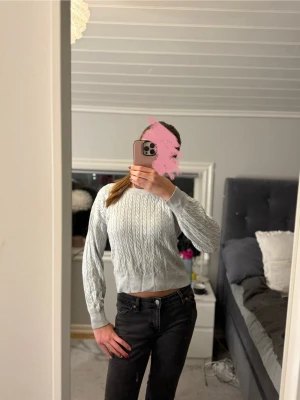 Ljusgrå stickad tröja - Supersnygg ljusgrå lite croppad stickad tröja med kabelstickat mönster. Tröjan har långärmade ärmar och bred ribbad kant vid midjan och ärmsluten. Den är från Cubus i storlek 146/152 men passar XS/XXS. Skriv om du har några funderingar!💕
