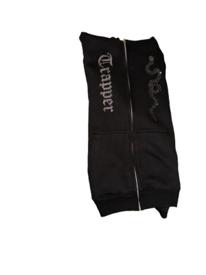 Svart tröja med Rhinestone - Rhinestone stenar som det står ”Trapper” på med en orm, använt 3 gånger.