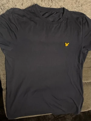 Lyle and scott t-shirt - Snygg och stilren T-shirt från Lyle & Scott med den klassiska gula örnloggan på bröstet. Enkel design som passar både till vardag och mer uppklädda tillfällen.
