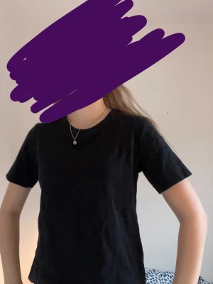 Svart t-shirt från Wera - En stilren svart t-shirt från Wera med klassisk rund hals och korta ärmar. Modellen är enkel och passar perfekt till jeans eller shorts. Materialet är mjuk bomull som känns skönt mot huden. Snygg och tidlös basic som alltid funkar.