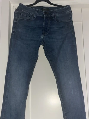 Jack & Jones Slim Glenn  - Jack & Jones jeans i modellen Slim Glenn. Jeansen har endast en defekt, och den sitter nära gylfen. Annars är jeansen helt perfekta då passformen är väldigt bra.