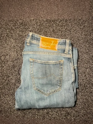 Jacob Cohen jeans - Säljer ett par ljusblå jeans från Jacob Cohen med klassisk femficksdesign och snygga slitningar på benen i storlek w34, mycket bra skick!
