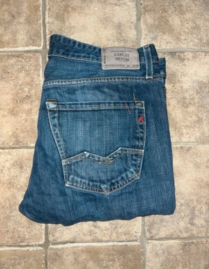 Replay Waitom jeans - Snygga blå jeans från Replay Denim med klassisk femficksdesign och raka ben. Midja 46cm, längd 108cm. Storlekslappen är borta W34 och jag bedömer dem till att vara L34 också. Modellappen är även den borta men modellen är Waitom. JAG SKICKAR EJ FLER BILDER NÄR JAG BÄR JEANSEN! för storleksguide hänvisar jag till måtten och för bättre inblick i passformen rekommenderar jag att googla på modellnamnet. :) S4