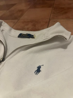 Ralph Lauren 1/4 zip - Säljer en lite schysstare 1/4 zip i bra skick. Finns dock en jätteliten skada som inte syns på kamera.  Nypris - 1200 Skick - helt okej