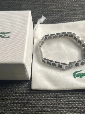 Lacoste Armband - Säljer nu mitt armband i mycket bra skick, Storlek M, motsvarar 21cm. Passar till alla tillfällen och outfits