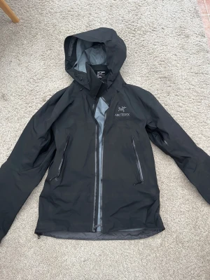 ARC’TERYX BETA AR JACKA - Säljer jackan då den inte används längre. Jag använde den främst som skaljacka i skidbacken, men funkar utmärkt som regn jacka, vandringsjacka eller snarlikt.  Jackan är i fint skick och varsamt använd. Om du söker en Arcetryx jacka och inte vill betala nypris är detta ett solklart val.  Modellen heter Beta AR.  Storleken är Small.  Nypris idag är 6999kr.   Hojta till om du undrar något eller vill ha fler bilder på något:)