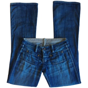 Blåa lowwaist flare/ bootcut jeans, 2000tal/ 70tal - Coolaste lågmidjade jeansen med fickor i fram och inga i bak! (jeansen är vändbara, går alltså att använda från båda håll) 100% bomull, Midjemått 74cm, Grenhöjd 19cm, Innerbenslängd 84cm, Benöppning rakt över 24cm