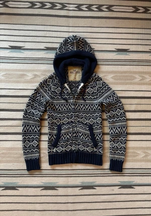 Blå/vit stickad zip hoodie från hollister - Sjukt snygg, eftertraktad o unik hoodie från hollister. Svår o få tag på, använd men utan defekter!