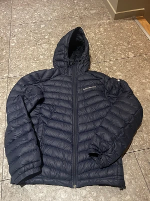 Mörkblå  Peak Performance Frost Down H – CNN lätt & varm dunjacka 🔥 - Säljer en Peak Performance Frost Down H – en stilren och funktionell dunjacka i klassisk mörkblå. Väldigt lätt men samtidigt riktigt varm, perfekt för höst, vinter och kalla vårdagar.  ✔️ Original Peak Performance ✔️ Modell: Frost Down H ✔️ Material: Pertex® Microlight ECO – vindtät, slitstark och miljövänligare ✔️ Dunjacka med hög komfort och snygg passform ✔️ Fint begagnat skick ✔️ Storlek S  En riktig Peak-klassiker som funkar både till vardag och stadsliv. Nypris betydligt högre.