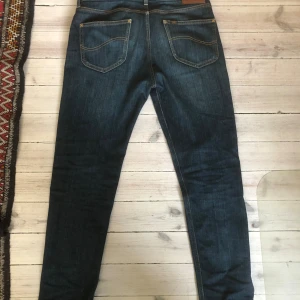  Lee slim fit jeans - Snygga mörkblå jeans från Lee med klassisk femficksdesign och kontrastsömmar. Modellen är slim fit med normal passform,  storlek W30 och L32. Perfekta för dig som gillar en stilren och tidlös look.