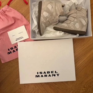 Beige Isabel Marant wedge sneakers - Säljer ett par beigea Isabel marants eftersom att de inte kommer till användning!! Det finns en liten röd prick på ena skon som man kan se på tredje bilden, man kan även rengöra skorna om man vill att de ska se nyare ut!❤️ skobox, äkthetsbevis tillkommer även med skorna. De är relativt använda❤️ Storlek 37, går att bude ner priset❤️