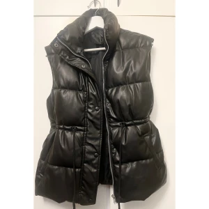 Blank väst - Superfin väst i blankt material! Snörning i midjan så man kan dra åt. Perfekt till hösten! 