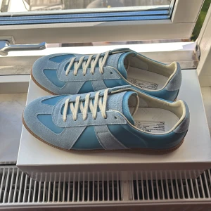 Maison Margiela blå sneakers - Sprillans nya gats från maison margiella. Köpta i Paris på galleries Lafayette, har kvitto. Allting ingår, box och dustbags! Hör gärna av er om ni har frågor!!!! Mvh Knut 
