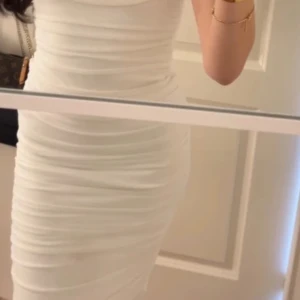 Vit tight långklänning med slits - Säljer en vit långklänning med tight passform och snygg rynkad effekt över hela klänningen. Den är perfekt o använt EN GÅNG. Den är i super bra material 