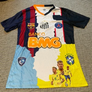 Neymar Jr collage fotbollströja  - Unik Neymar Jr collage fotbollströja från Umbro med tryck från flera klubbar: Barcelona, PSG, Santos, Al Hilal och Brasilien. Flera färger i blockmönster, kortärmad med V-ringning. Materialet är lätt och andas, perfekt för fotboll eller streetwear.