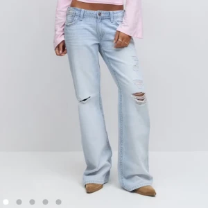 Ljusblå bootcut jeans med slitningar - Slutsålda straight jeans ifrån Gina. Jag har sprättat upp dem där nere så att dem blir längre men har bara använt två gånger. Storlek 164