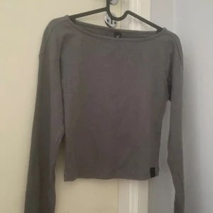 Grå ribbad långärmad topp XS - Säljer en grå ribbad långärmad topp storlek XS. Det är typ en magtröja/tränings tröja