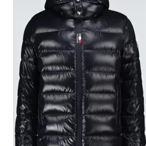 Svart Moncler dunjacka med huva - Säljer en svart, glansig dunjacka från Moncler med huva och klassisk quiltad design. Jackan har dragkedja framtill, Moncler-logga på ärmen och coolt serietryck på insidan. Perfekt för dig som vill ha en varm och snygg jacka med street vibe.