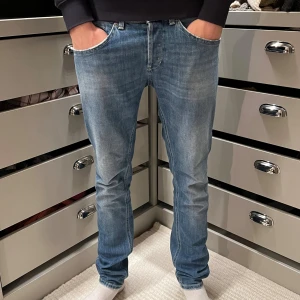 Dondup George 30 - Säljer ett par ljusblå Dondup George jeans med klassisk femficksdesign och snygga detaljer på bakfickorna. Passformen är slim fit och Perfekta för dig som gillar en stilren och modern look.             Skick=9,5 nypris=3000