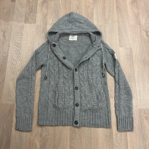 Stickad cardigan  - En skit det stickad cardigan med luva. Den är varm och skön nu inför höst och vinter. Den är i princip ny. Vårat pris endast 799 priset kan alltid diskuteras! Finns inte att köpa nånstans ny