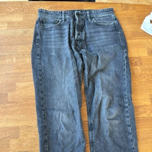 Jack & Jones svarta jeans straight fit - Säljer ett par svarta jeans från Jack & Jones med klassisk femficksdesign och raka ben. Jeansen har en mörk tvätt och tydliga sömmar, tillverkade i slitstarkt denim. Perfekta för dig som gillar en enkel och tidlös look. Storlek 32-32