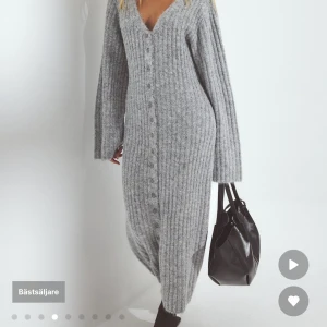 Grå stickad långklänning NA-KD - Supermysig grå ribbstickad långklänning från Nakd. med v-ringning och knappar hela vägen framtill. Klänningen har långa ärmar och en figurnära passform. Endast testad!! Säljer då de inte riktigt va min stil 