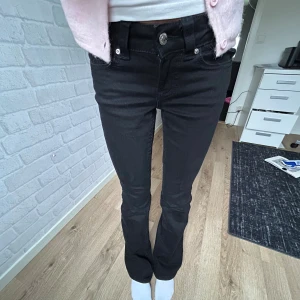 Svarta bootcut jeans med knappar - Svarta bootcut jeans från Gina Tricot i stl 32 med knappar där bak, nya!!