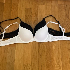 Svart och vit spets-bh oanvända  - Två snygga T-shirt bh:ar, en svart och en vit med reglerbara band. Helt oanvända men lappar borttagna. Vadderad med lätt push-up effekt. Strl 75 A. Säljer pga kommer inte till användning 