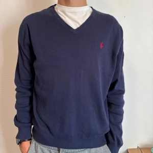 Stickad v-ringad Ralph Lauren - Säljer denna mörkblå stilrena stickade Ralph Lauren tröja. Inga defekter och överlag mycket bra skick. Modellen är 189cm lång. Tveka inte vid prisförslag eller frågor.✍️