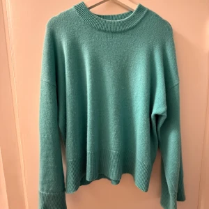 Turkos stickad tröja  - Mysig turkos Kashmir tröja med bred ribbad kant vid hals, ärmslut och nederkant. Snyggaste modellen!!!