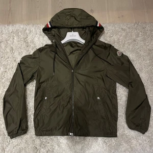 Olivgrön vindjacka från Moncler - Säljer nu denna supersnygga windbreaker från moncler🤩 Jackan är i jättebra skick och har endast en liten defekt på armen💫 Tveka inte på att höra av dig vid frågor och funderingar! 