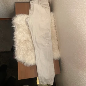 Ljusgrå jeans från Dsquared2 - Säljer ett par ljusgrå jeans från Dsquared2 med slitna detaljer och patchar på benen. Klassisk femficksmodell med normal passform och raka ben. Byxorna har Dsquared2-logga vid gylfen och bak på linningen. Perfekta för dig som gillar streetstyle.