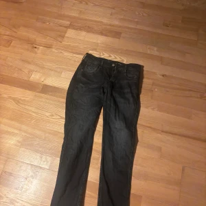 Svarta Replay jeans, modell Anbass - Säljer ett par svarta Replay Anbass jeans i klassisk femficksmodell. Jeansen har raka ben och normal passform, tillverkade i mjukt jeanstyg. Snygga detaljer och diskret Replay-märke bak i midjan. Perfekta för dig som gillar stilrena svarta jeans.