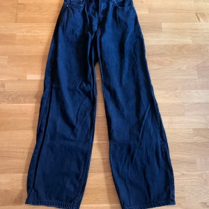 Svarta wide jeans från Dr Denim - Säljer ett par svarta jeans från Dr Denim i modellen Donna. De har hög midja, raka ben med wide fit och klassisk femficksdesign. Materialet är jeans och de stängs med dragkedja och knapp. Perfekta för dig som gillar en avslappnad och trendig look.