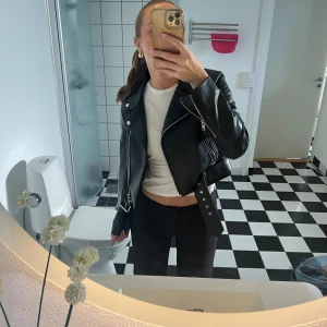 Svart skinnjacka från zara - Säljer denna skinnjacka från Zara. Den är lite lätt croppad och har små fickor i sidorna, bälte i midjan och justerbara dragkedjor i ärmarna. Den är endast använd ett fåtal gånger och är i fint skick🩷🩷🩷