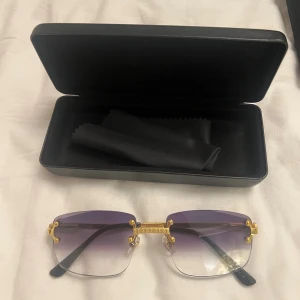 Kiko frames solglasögon  - Snygga solglasögon med rektangulär form och lila tonade glas. Glasögonen har guldfärgade detaljer och svarta skalmar. Kommer med svart fodral och putsduk. Perfekt för dig som vill sticka ut med en lyxig vibe. Köpte för 549kr 