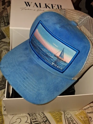 Blå&vit Velvet keps - Snygg Velvet keps från WALKER THE BRAND. Jätte sällsynt då den inte har sålts på något år eller två nu och har en väldigt stilren färg. Walkers hemsida finns inte längre därav priset och deras kepsar säljs inte längre. Säljer dock denna goding då jag är intresserad i annat. Den är rätt använd, skriv om du vill ha mer bilder!