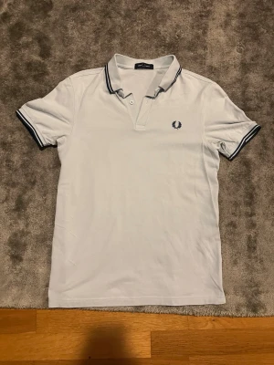 Fred Perry pique - Säljer en snygg blå Fred Perry pikétröja. Som ny sitter perfekt i armarna och bra runt kroppen. Perfekt till sommaren