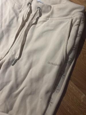 Beiga mjukisbyxor från Calvin Klein - Säljer ett par beiga mjukisbyxor från Calvin Klein. Älskar dessa byxor men var tyvärr blivit lite små:/ Dock inte haft chans att använda så mycket 