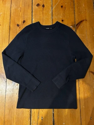 Mörkblå stickad tröja J.Lindeberg M - Ny pris 1200kr!! Mörkblå stickad tröja från J.Lindeberg i storlek M. Tröjan har rund hals, ribbade muddar och långärmad passform. Enkel och stilren design som funkar till många olika looks. Materialet är mjukt och bekvämt.
