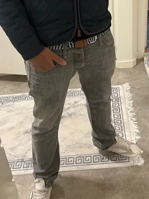 Replay grå jeans  - Säljer ett par gråa Replay jeans med klassisk femficksdesign och raka ben. Jeansen har en diskret tvättad look och Replay-logga på bakfickan. Materialet är mjukt jeans-tyg som sitter skönt och passar till det mesta. Perfekt för dig som gillar stilrena och avslappnade jeans.