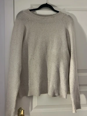 Beige stickad tröja med rund hals - Säljer en enkel och stilren beige stickad tröja med rund halsringning. Tröjan har lång ärm och en mjuk, bekväm passform som passar perfekt till jeans. Perfekt basplagg för garderoben!